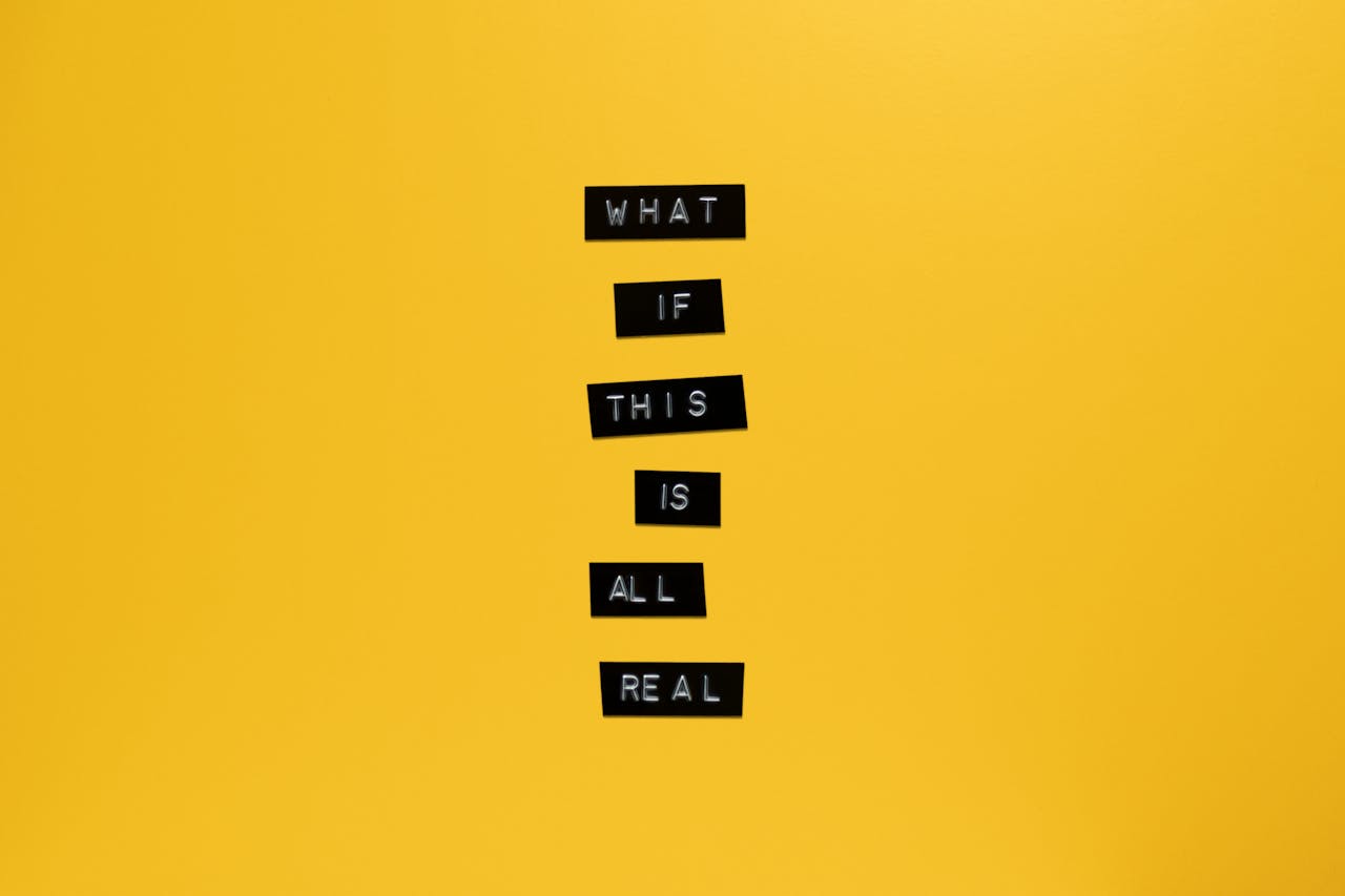 Inspirational text 'What if this is all real' on yellow surface.